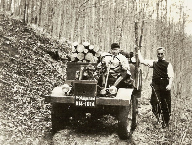 Erste „Prüffahrt“, noch ohne Fahrerhaus, am 9. Oktober 1946. Chefkonstruk¬teur Heinrich Rößler am Steuer, rechts Hans Zabel, der Namensgeber des Unimog. ; First test drive on 9 October 1946. Chief designer Heinrich Rößler at the wheel and Hans Zabel, who gave the Unimog its name, on the right.;